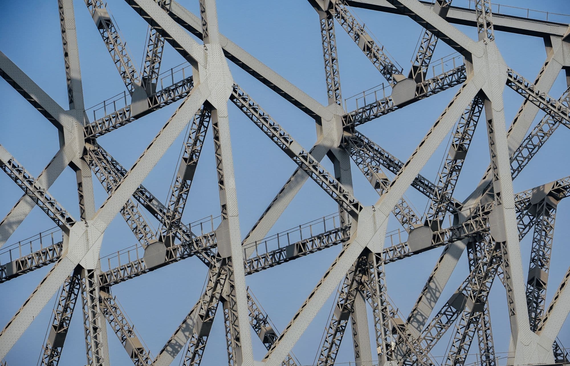 Intersecting steel structural beams against the sky.