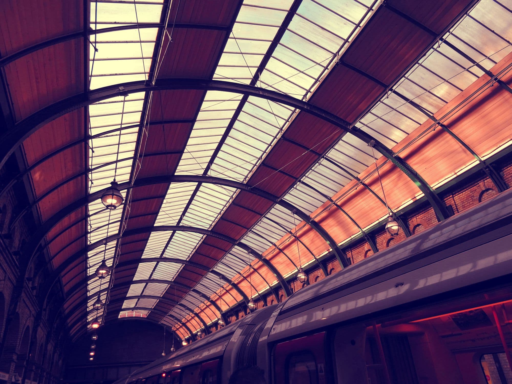 Sweeping steel-and-glass arched hall, monumental engineered structure.