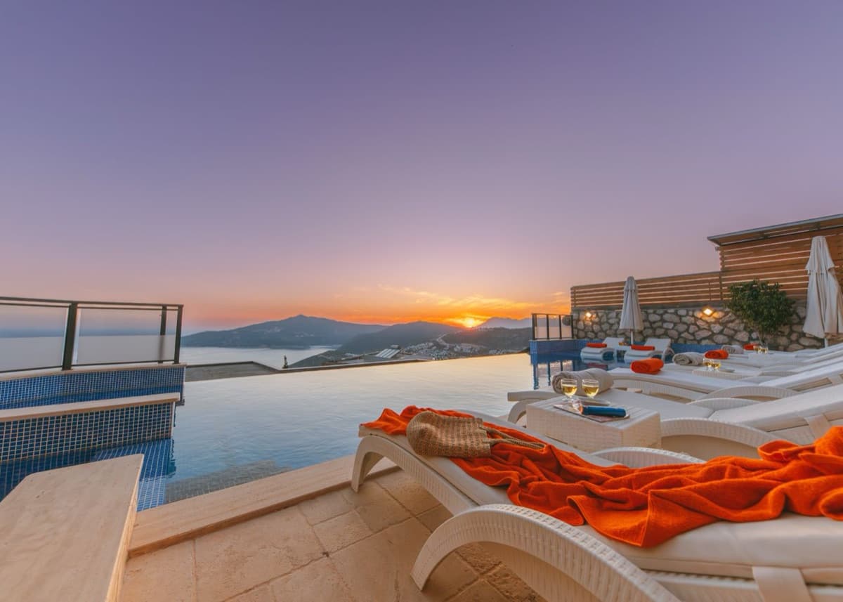 Infinity pool and terrace overlooking the sea at sunset