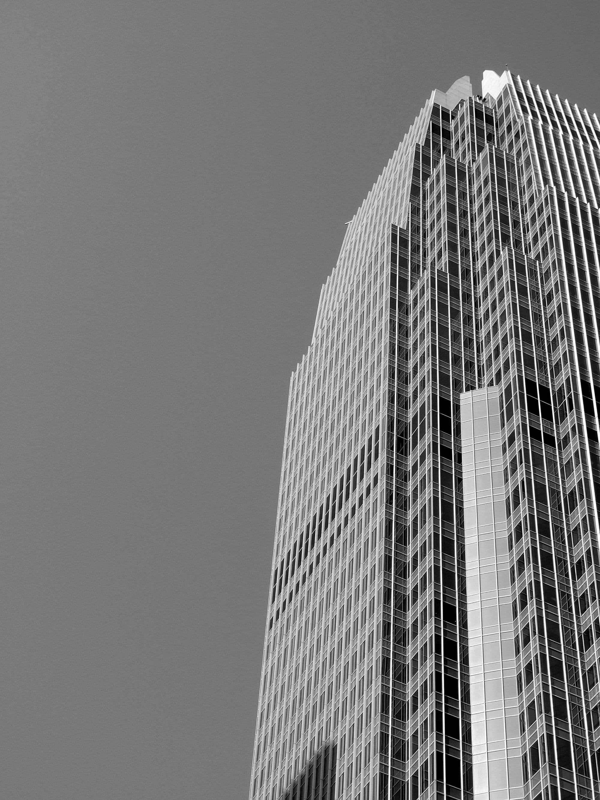 Commercial glass-and-steel skyscraper facade, seen from below.